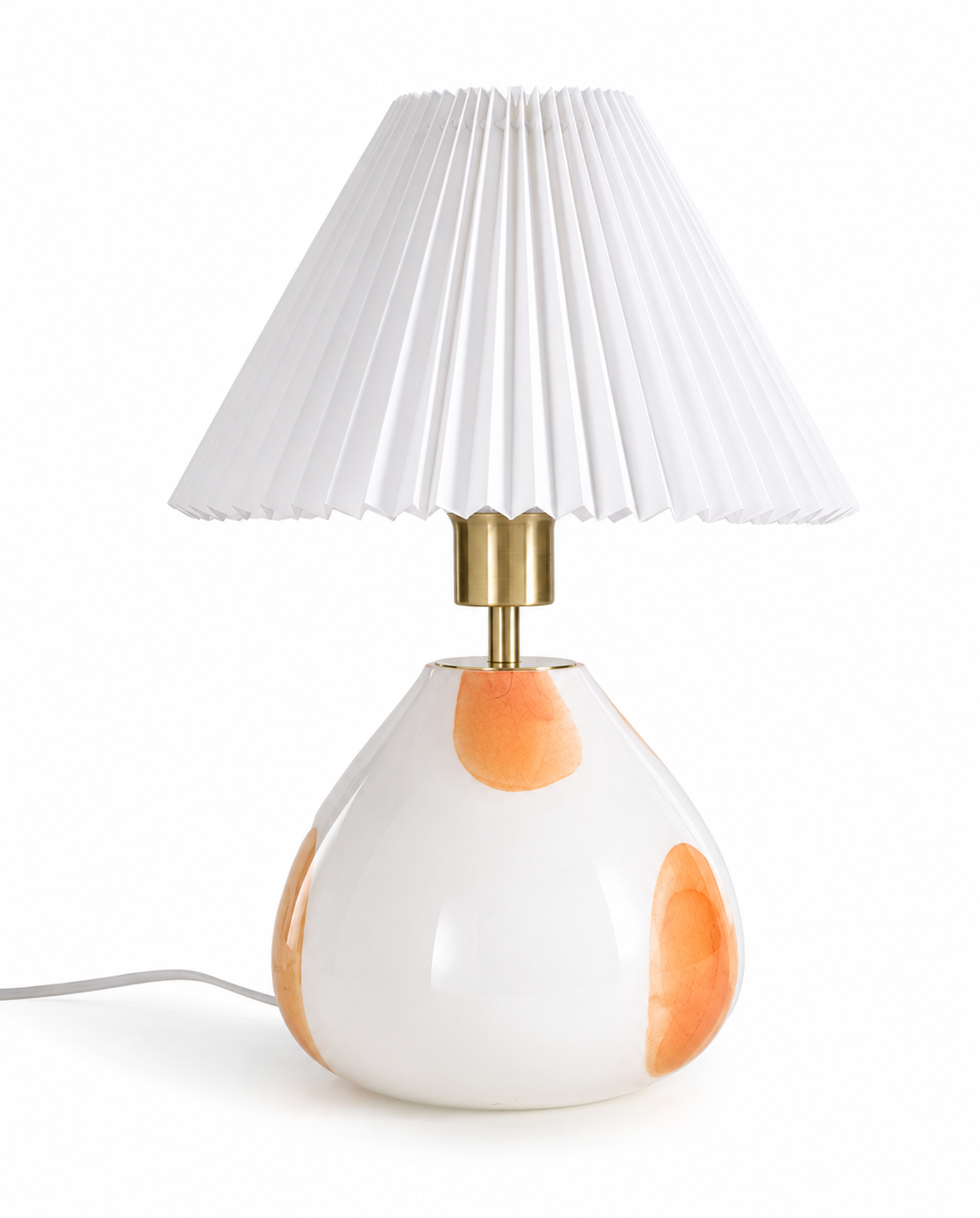 Front view of The Very Collection spotted glass table lamp with white pleated shade, brass stem and white glass base for modern home lighting.